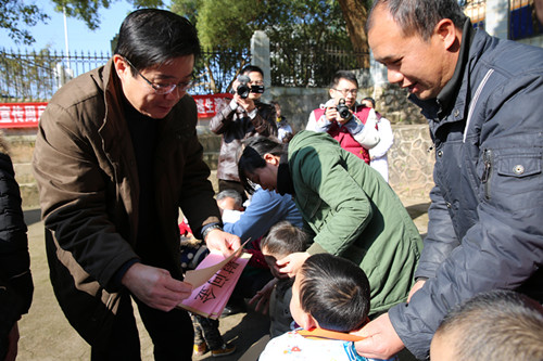 图为市委副书记唐毓流(右四)到钟山县公安镇大田村